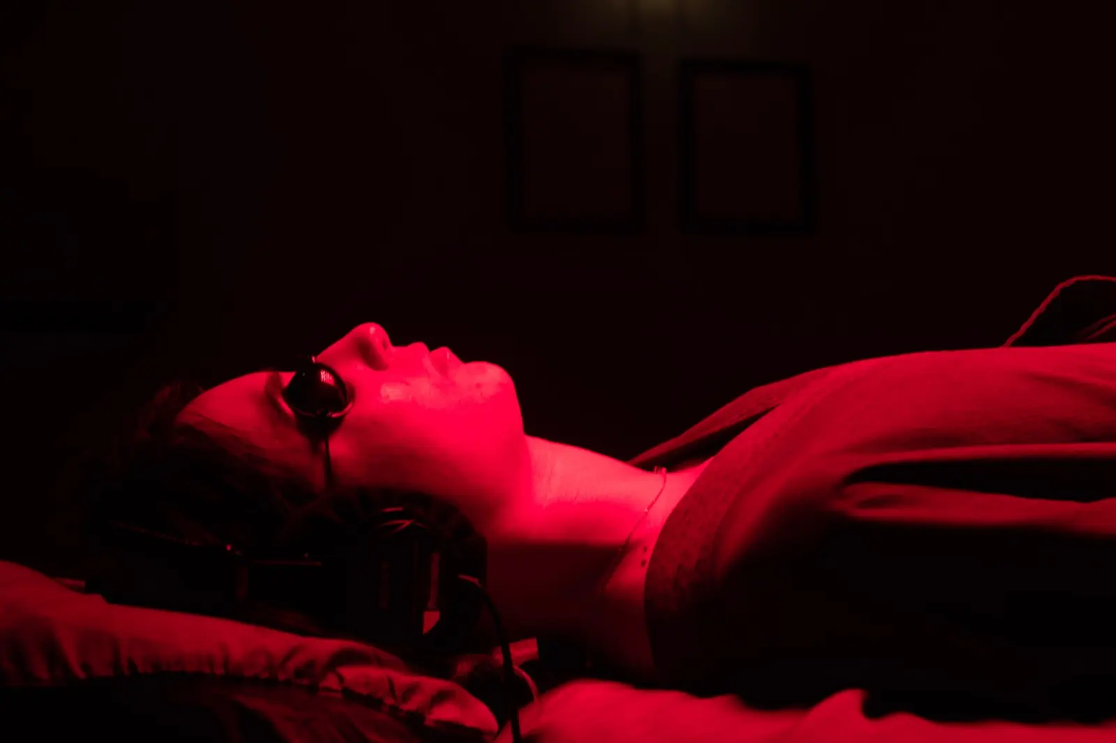 A guest with headphones resting in red light